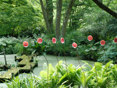 garden art featuring multi coloured glass flowers on tall metal stalks