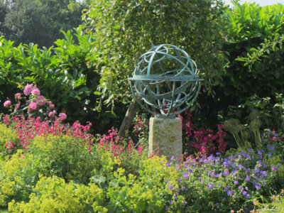 david harber bronze verdigris armillary sundial on stone plinth in planted border